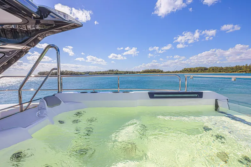 Hideout Yacht Photos Pics Luxurious Sunseeker 88 Yacht 2025 with jacuzzi, overlooking serene ocean and blue sky.
