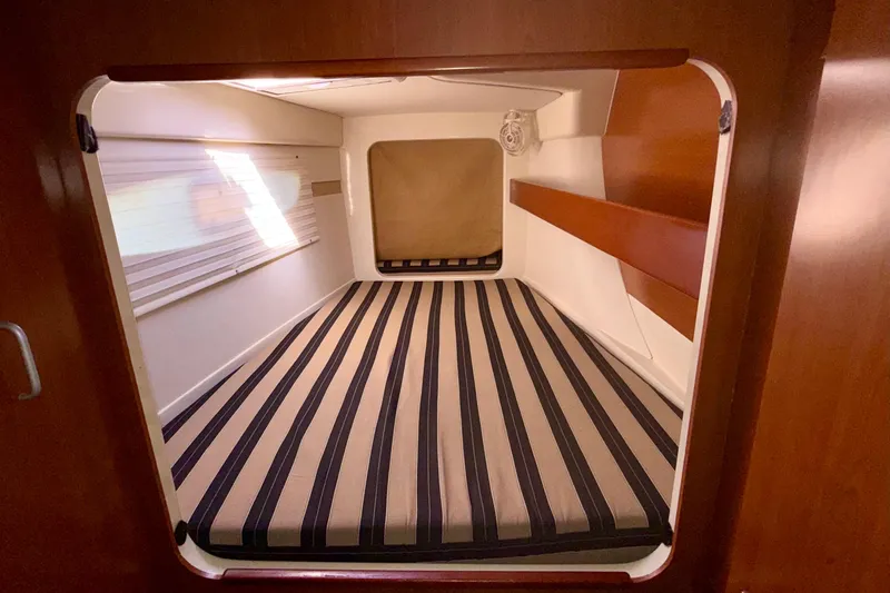  Yacht Photos Pics Cabin interior of 2012 Leopard 39 yacht with striped bedding and wooden accents.
