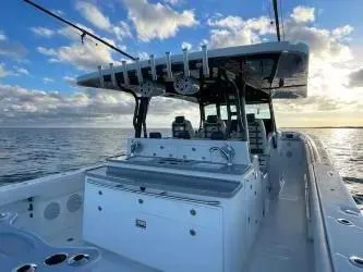  Yacht Photos Pics 2019 HCB 53 Sue&ntilde;os boat on calm ocean at sunset, featuring spacious deck and fishing equipment.