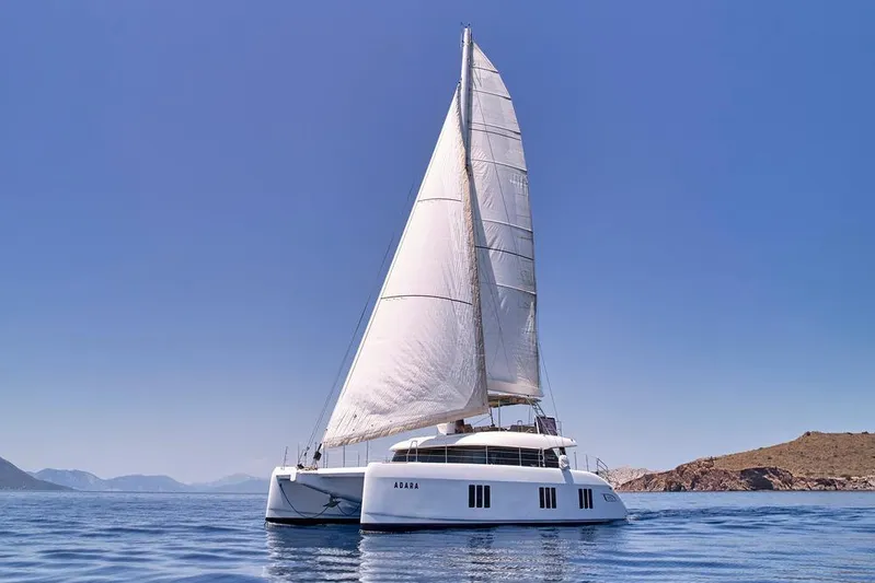 Adara Yacht Photos Pics 2020 Sunreef 50 catamaran sailing on calm blue waters under clear skies.