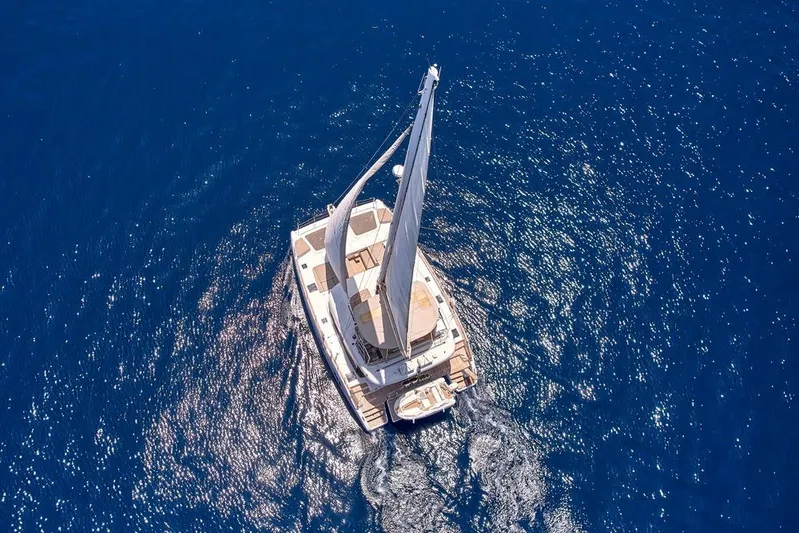 Adara Yacht Photos Pics Aerial view of 2020 Sunreef 50 catamaran sailing on deep blue ocean.