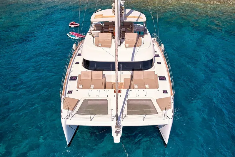 Adara Yacht Photos Pics Luxurious 2020 Sunreef 50 catamaran on clear blue water, showcasing spacious deck and elegant design.
