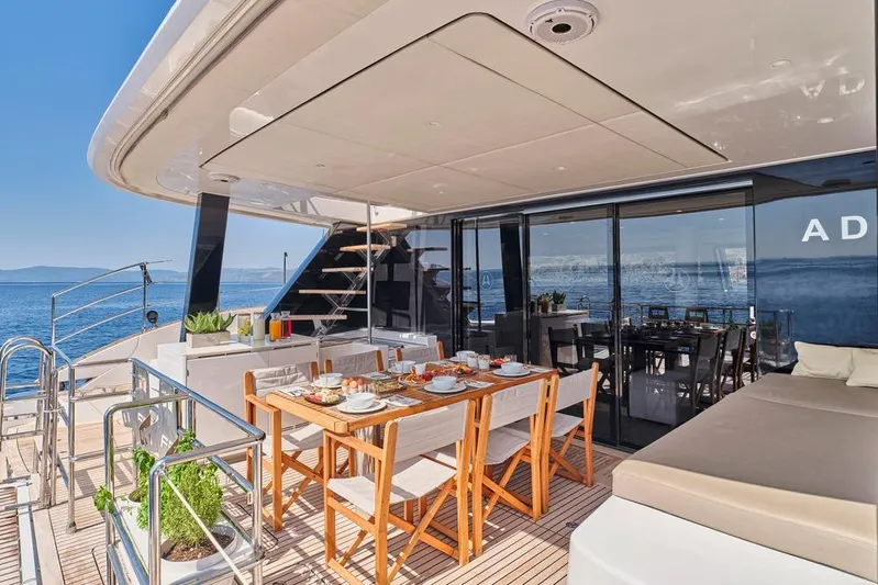 Adara Yacht Photos Pics Luxurious Sunreef 50 yacht deck with dining area, ocean view, and modern design, 2020 model.