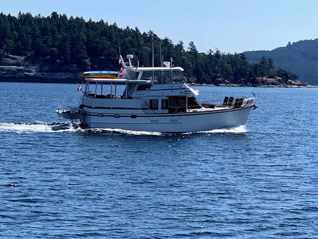 Blue Agave Yacht Photos Pics 1983 Ocean Alexander 43 Flush Aft Deck yacht cruising on a scenic waterway.
