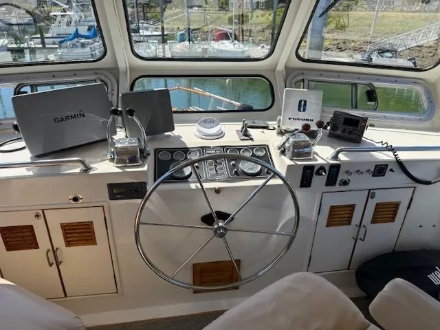 Blue Agave Yacht Photos Pics Helm of 1983 Ocean Alexander 43 Flush Aft Deck with navigation equipment and steering wheel.