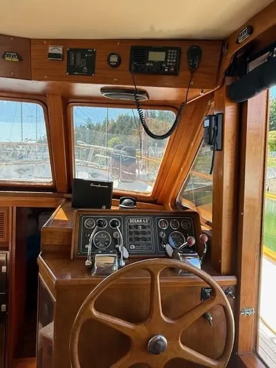 Blue Agave Yacht Photos Pics 1983 Ocean Alexander 43 Flush Aft Deck helm with wooden steering wheel and navigation instruments.