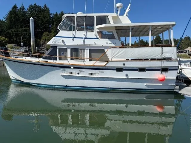 Blue Agave Yacht Photos Pics 1983 Ocean Alexander 43 Flush Aft Deck yacht docked in calm waters.