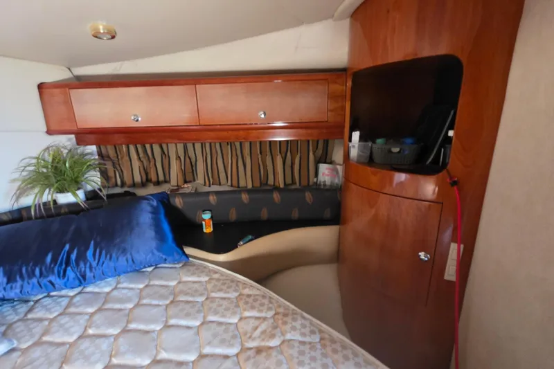  Yacht Photos Pics Interior of 2002 Regal Commodore 4260 yacht with wooden cabinets and cozy bedding.