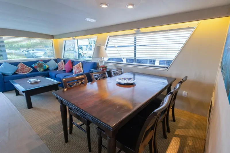  Yacht Photos Pics Interior of 1987 Hatteras 70 Cockpit Motor Yacht with dining table and blue sofa.