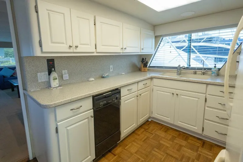  Yacht Photos Pics Kitchen interior of 1987 Hatteras 70 Cockpit Motor Yacht with white cabinets and large window.