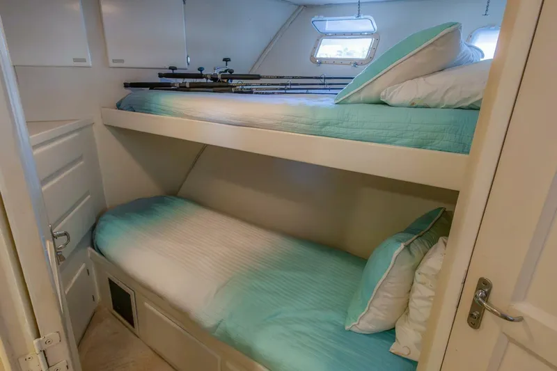  Yacht Photos Pics Bunk beds in 1987 Hatteras 70 Cockpit Motor Yacht cabin with fishing rods and teal bedding.