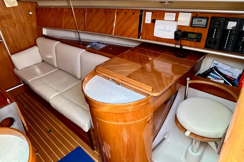 Marianne Yacht Photos Pics Interior of 1991 Beneteau First 38s5 yacht with wooden cabinetry and white seating.