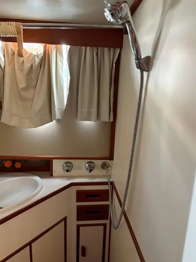  Yacht Photos Pics 1986 Grand Banks 36 Classic yacht bathroom with shower, sink, and curtains.