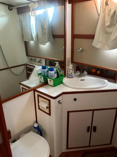  Yacht Photos Pics Bathroom interior of 1986 Grand Banks 36 Classic yacht, featuring sink and cleaning supplies.