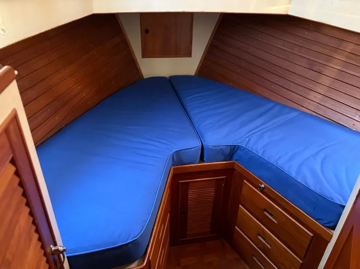  Yacht Photos Pics Interior cabin of 1986 Grand Banks 36 Classic with blue cushions and wooden cabinetry.