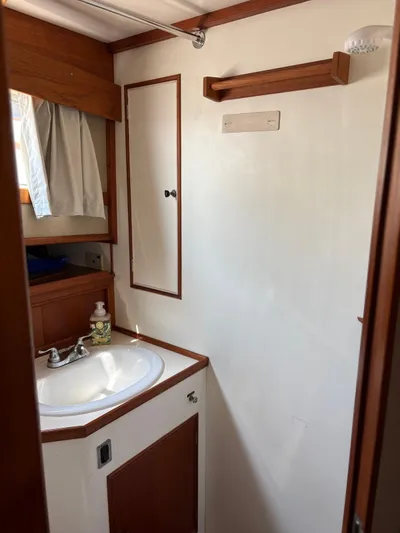  Yacht Photos Pics 1986 Grand Banks 36 Classic bathroom with sink, mirror, and wooden accents.