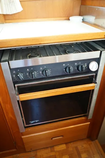  Yacht Photos Pics 1986 Grand Banks 36 Classic yacht kitchen with stove and oven, featuring wooden cabinetry.