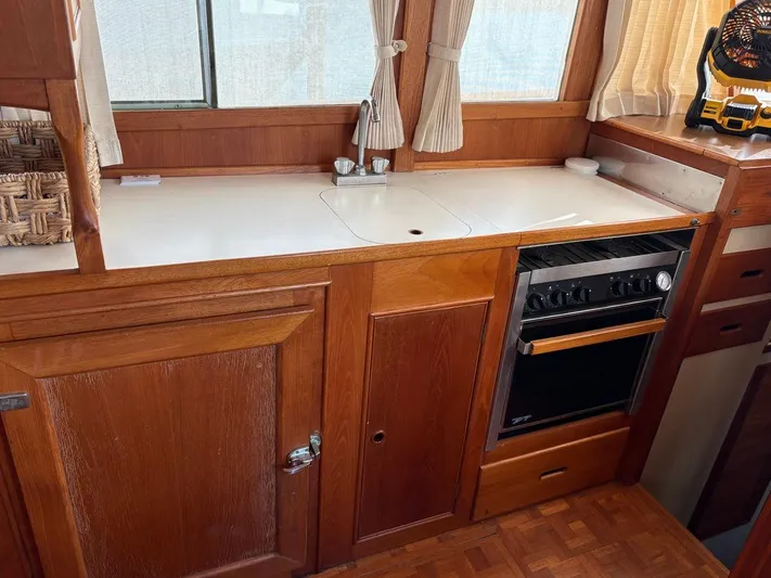  Yacht Photos Pics Wooden kitchen interior of 1986 Grand Banks 36 Classic boat with stove and sink.