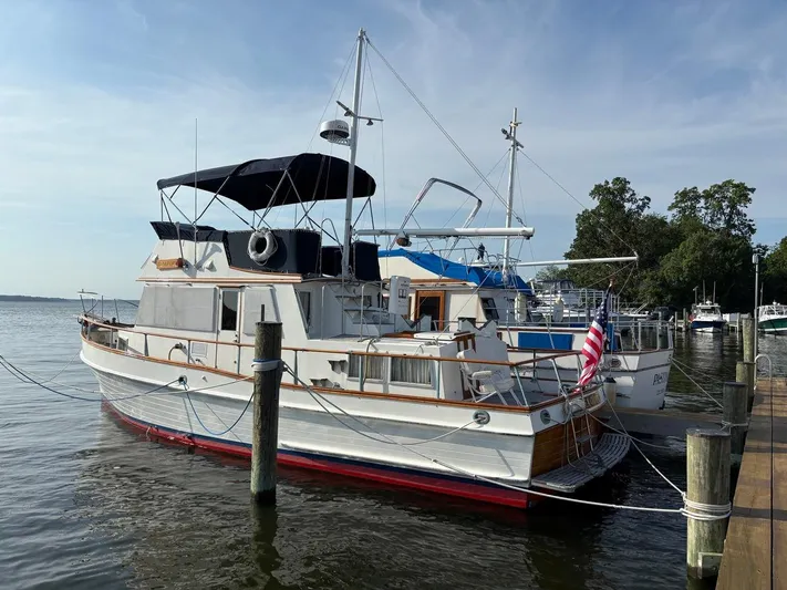  Yacht Photos Pics 1986 Grand Banks 36 Classic yacht docked at marina, featuring American flag and calm waters.