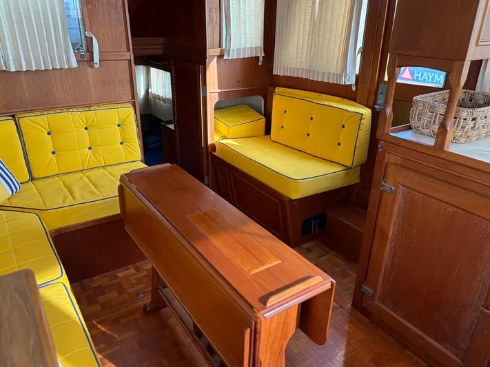  Yacht Photos Pics Interior of 1986 Grand Banks 36 Classic with yellow cushioned seating and wooden table.