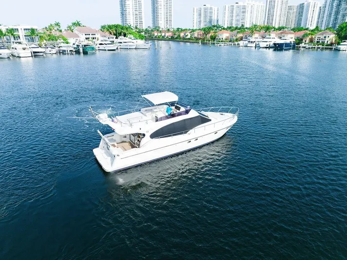  Yacht Photos Pics 2009 Ferretti Yachts 470 cruising in a marina with cityscape background.