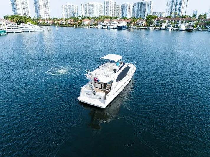  Yacht Photos Pics 2009 Ferretti Yachts 470 cruising in a marina with city skyline backdrop.