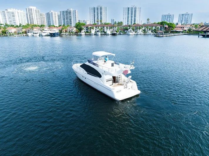  Yacht Photos Pics 2009 Ferretti Yachts 470 cruising in a marina with city skyline backdrop.