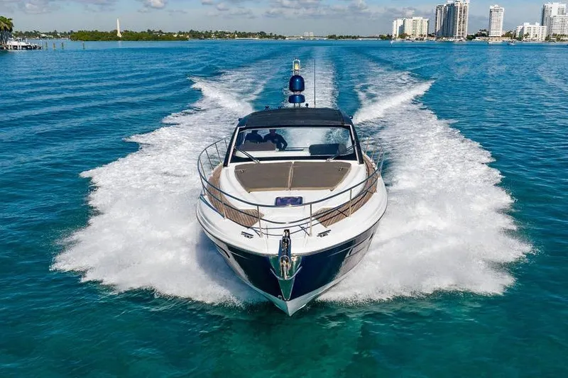 Relax Josephine Yacht Photos Pics 2022 Azimut Atlantis 45 yacht cruising on clear blue water, city skyline in background.