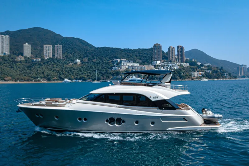 Mcy 70 Hk Yacht Photos Pics Luxurious 2014 Monte Carlo Yachts MCY 70 cruising near scenic coastal cityscape.