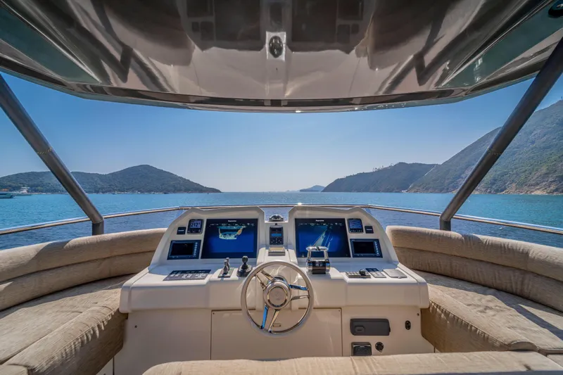 Mcy 70 Hk Yacht Photos Pics Cockpit view of 2014 Monte Carlo Yachts MCY 70, overlooking serene blue waters and distant hills.