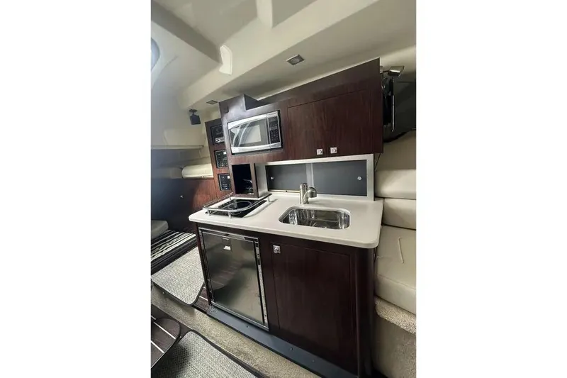  Yacht Photos Pics 2017 Monterey 295 Sport Yacht interior kitchen with sink, stove, and microwave.