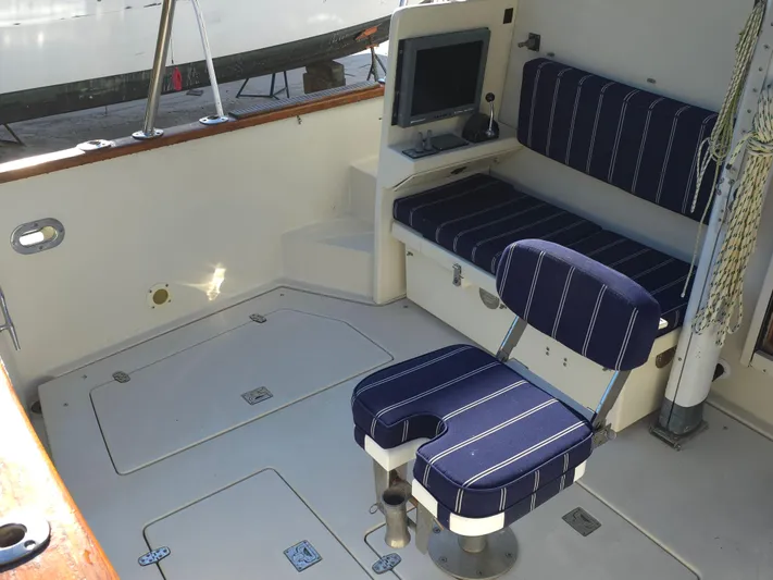 Lindy Yacht Photos Pics 2004 Legacy Sedan Flybridge interior with striped seating and navigation equipment.