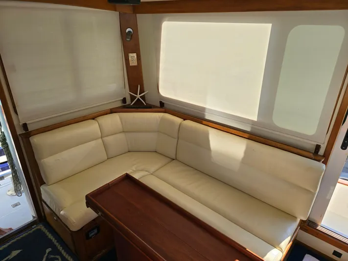 Lindy Yacht Photos Pics Luxurious interior of 2004 Legacy Sedan Flybridge with cream leather seating and wooden table.