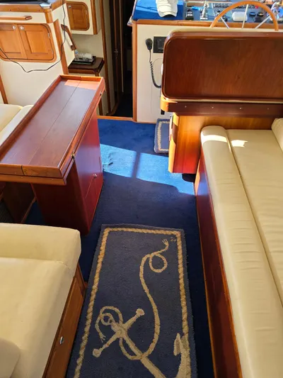 Lindy Yacht Photos Pics Interior of 2004 Legacy Sedan Flybridge with blue carpet and wooden furnishings.