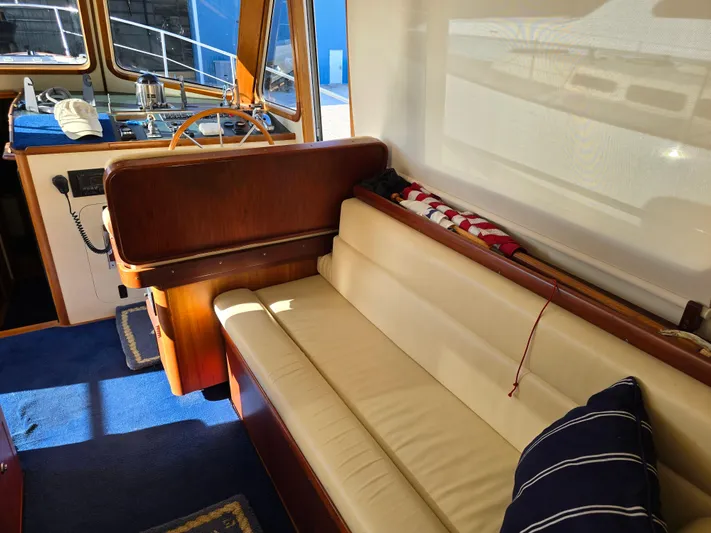 Lindy Yacht Photos Pics Interior of 2004 Legacy Sedan Flybridge with beige seating and wooden helm.