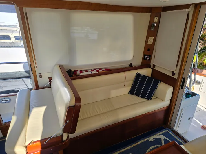 Lindy Yacht Photos Pics Interior of 2004 Legacy Sedan Flybridge with cream seating and striped pillow.