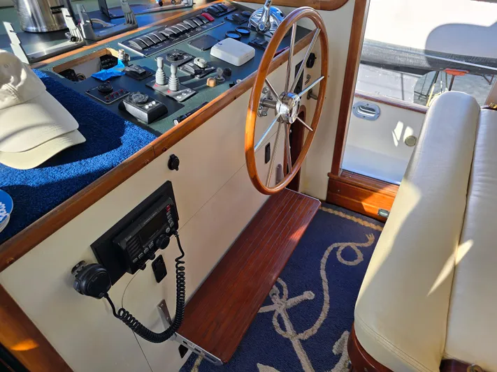Lindy Yacht Photos Pics 2004 Legacy Sedan Flybridge helm with wooden wheel, control panel, and nautical-themed decor.