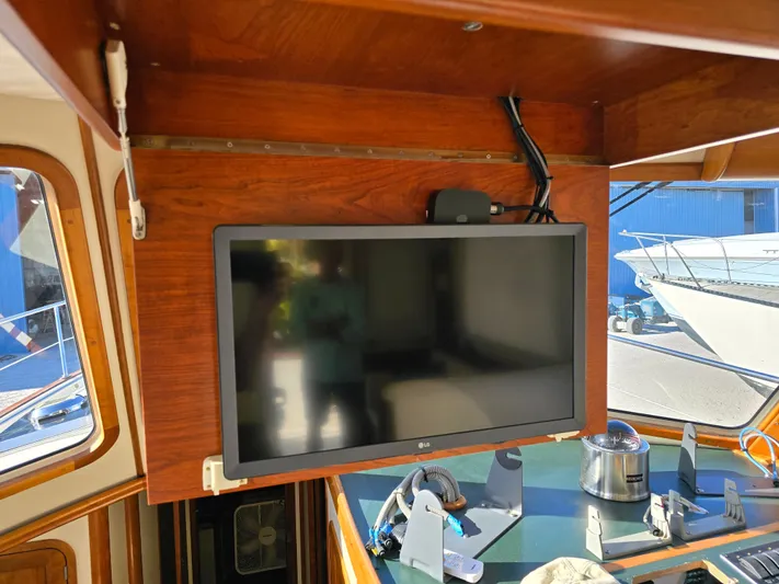 Lindy Yacht Photos Pics Flat-screen TV mounted on wooden panel inside 2004 Legacy Sedan Flybridge boat.