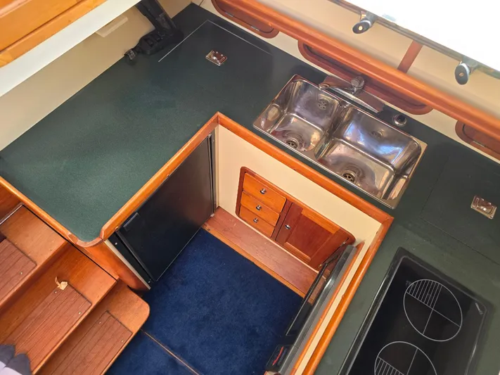 Lindy Yacht Photos Pics 2004 Legacy Sedan Flybridge kitchen with dual sinks, stove, and compact fridge.