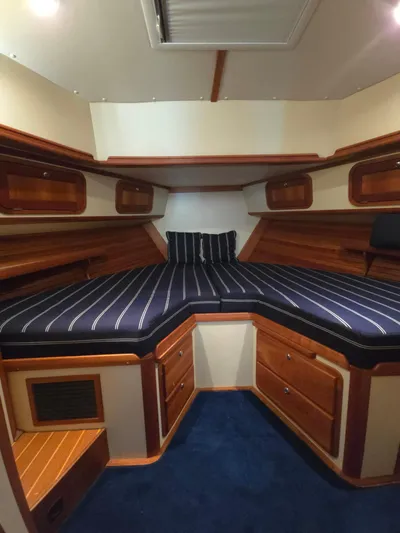 Lindy Yacht Photos Pics Interior cabin of 2004 Legacy Sedan Flybridge with striped bedding and wooden storage.