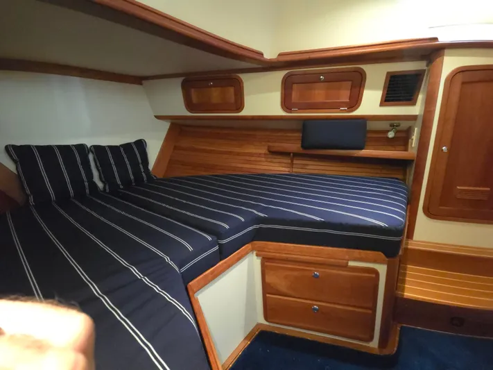 Lindy Yacht Photos Pics 2004 Legacy Sedan Flybridge cabin with striped bedding and wooden interior.