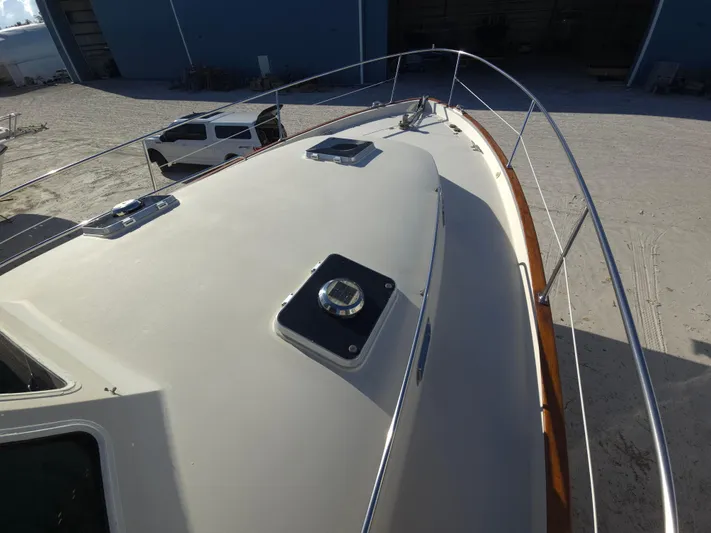 Lindy Yacht Photos Pics 2004 Legacy Sedan Flybridge boat deck with railing, parked near a white vehicle.