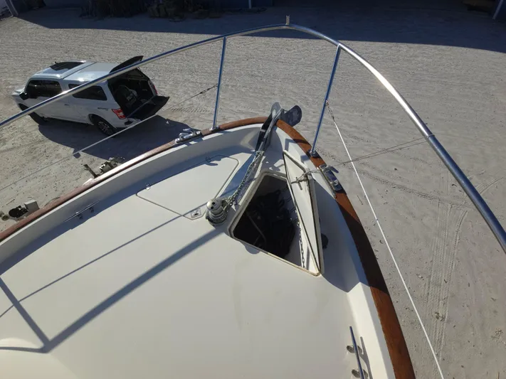 Lindy Yacht Photos Pics 2004 Legacy Sedan Flybridge boat with open hatch, parked car nearby on sandy ground.