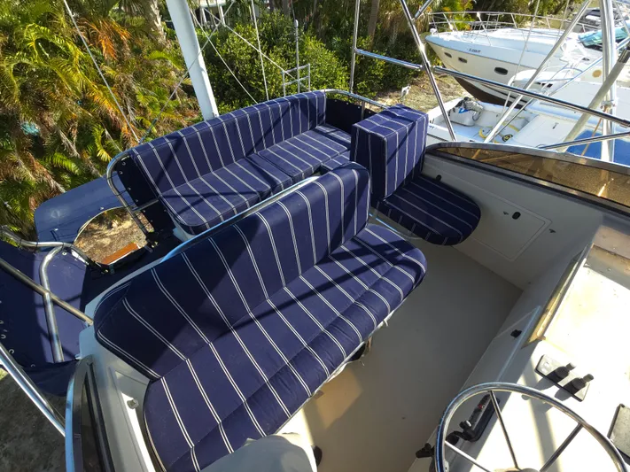 Lindy Yacht Photos Pics 2004 Legacy Sedan Flybridge with striped seating, featuring a spacious and comfortable layout.