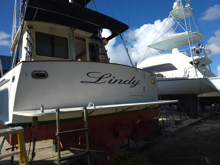 Lindy Yacht Photos Pics 2004 Legacy Sedan Flybridge boat named "Lindy" in a shipyard under clear skies.