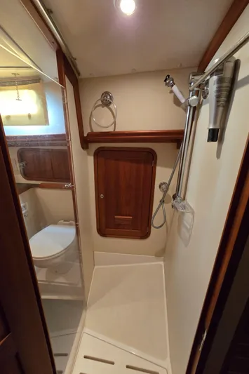 Lindy Yacht Photos Pics Compact bathroom in 2004 Legacy Sedan Flybridge with shower and wooden accents.