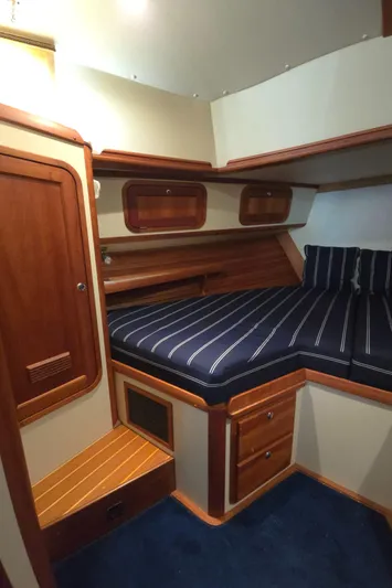 Lindy Yacht Photos Pics 2004 Legacy Sedan Flybridge cabin with wood accents and striped bedding.