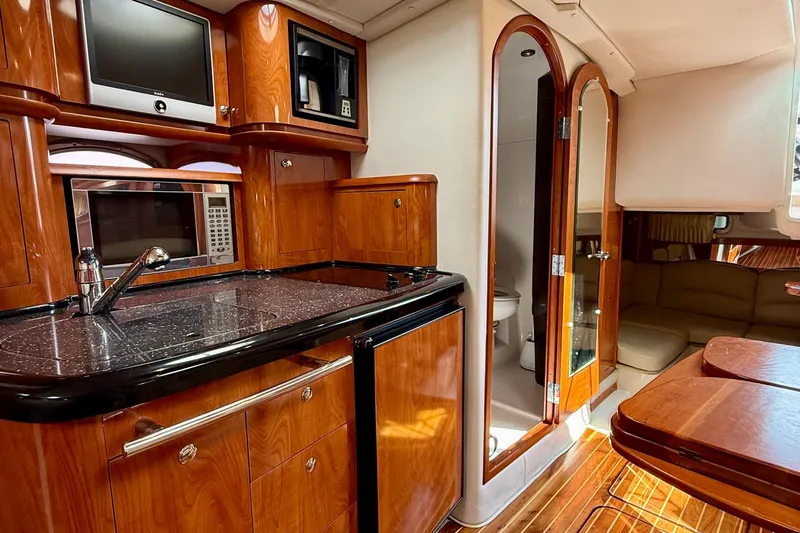 Yacht Photos Pics Luxurious 2008 Four Winns V358 yacht interior with kitchenette, wood cabinetry, and seating area.