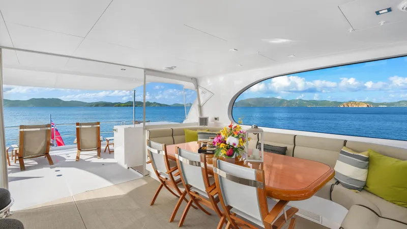 Sea Glass Yacht Photos Pics Luxurious Horizon PC74 yacht interior with ocean view, featuring dining area and lounge chairs, 2018 model.