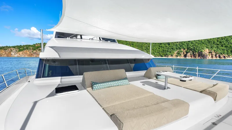 Sea Glass Yacht Photos Pics Luxurious Horizon PC74 yacht deck with sun loungers, ocean view, and clear blue sky.